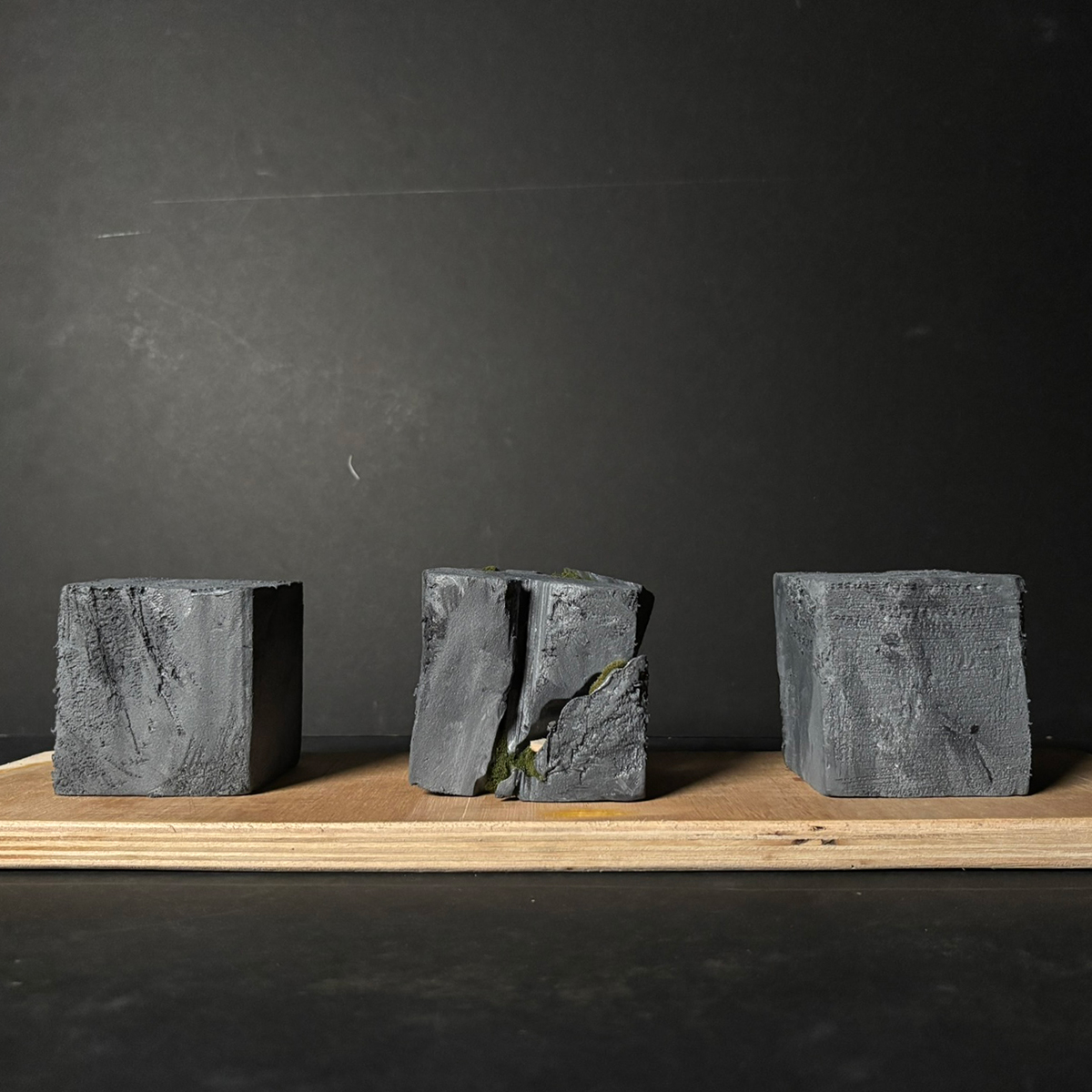 Concept model showing three blocks, two solid resembling the sensory-malnourished society, and one showing green emerging from the cracks, signifying the building.